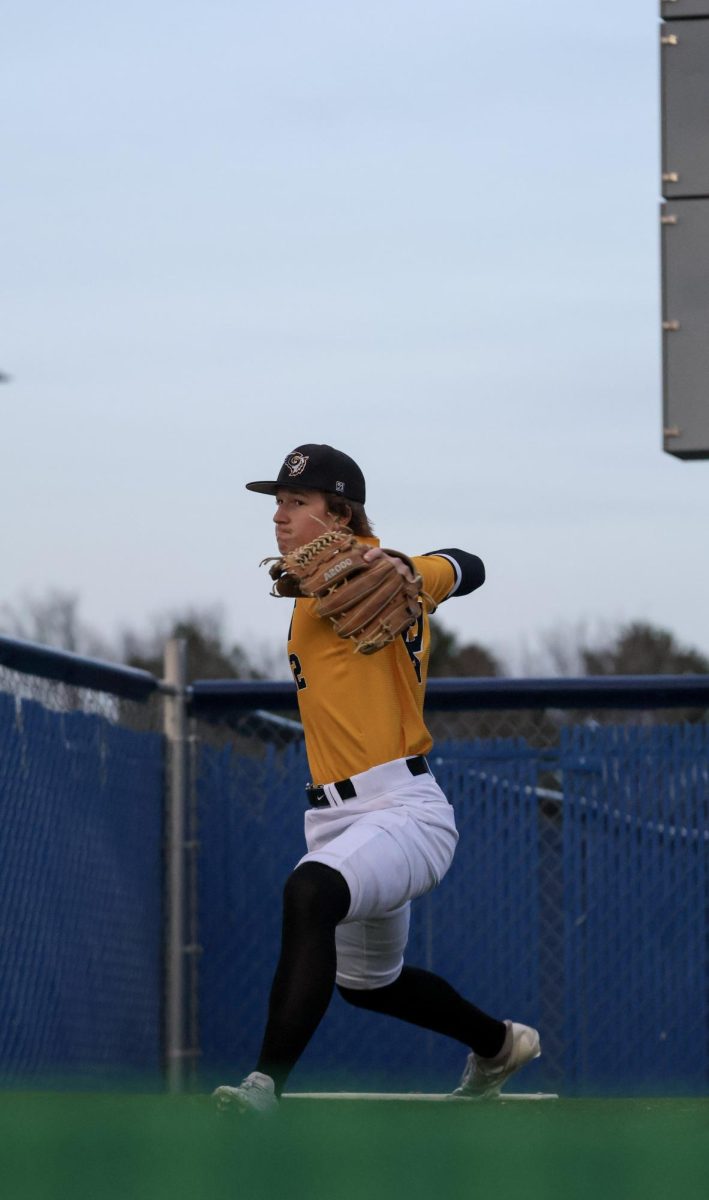 Before taking the mound to start the game against the Millard North Mustangs, junior Andrew Dowd warms up in the bullpen on April 3. The Griffins closed out the game 5-3 after five innings.