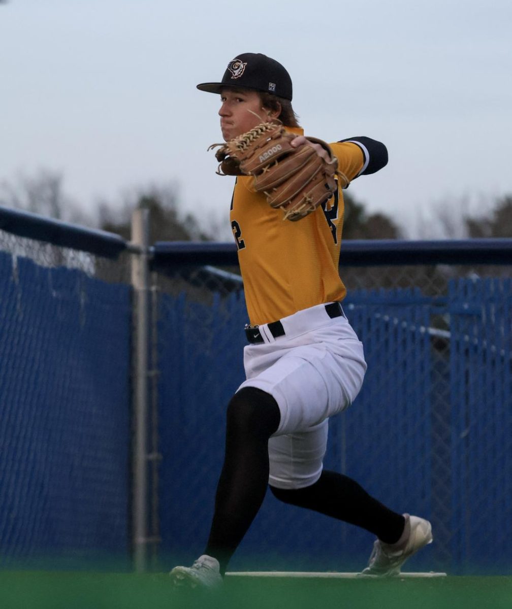 Before taking the mound to start the game against the Millard North Mustangs, junior Andrew Dowd warms up in the bullpen on April 3. The Griffins closed out the game 5-3 after five innings.