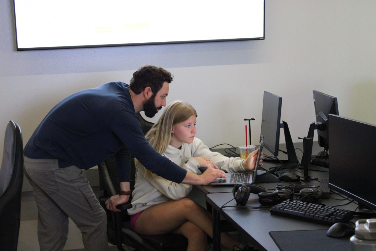 During her computer science basics class, junior Paige Stenneche gets help from her teacher, Adam Schwaninger, to decode a secret message. Using the graph she was given, she matched together letters to create a secret message.