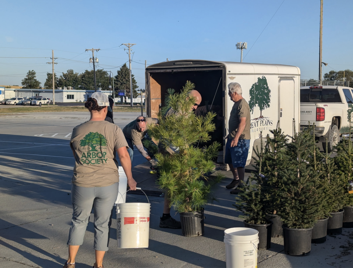 Members of the Tree Board unload trees from the back of the Great Plains Nursery truck as they prepare to give them away during the Tree Giveaway in 2024.