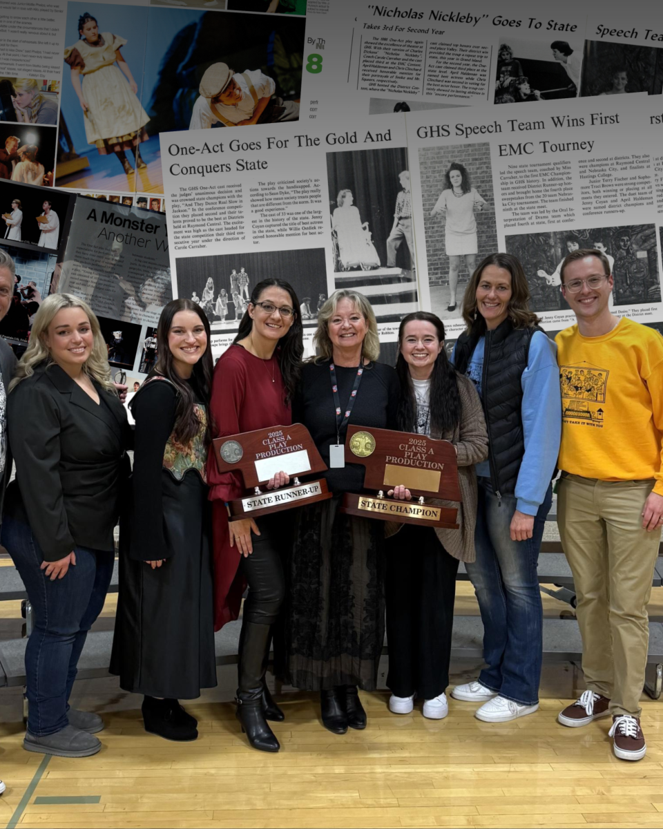 Carole Carraher stands with both 2025 NSAA Class A trophies, alongside the Gretna and Gretna East one-act directors. 