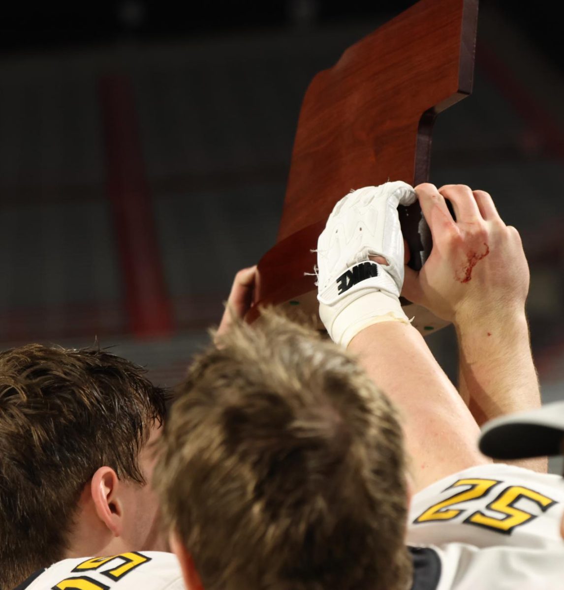Sweaty, bloody and tired, team members hoist the Class B State Runner-up trophy in to the air after an 11-2 season.