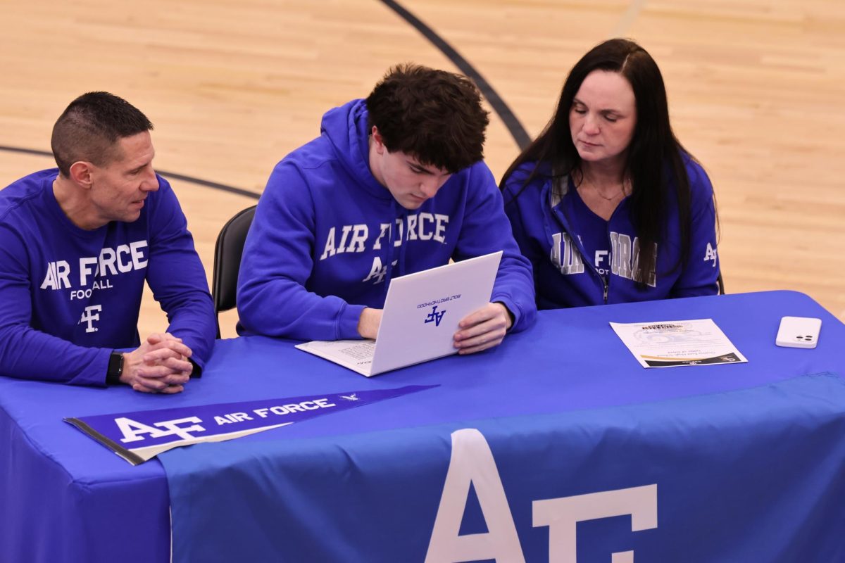 Signing his letter, senior Connor Sams commits himself to the Air Force Academy to play football. 