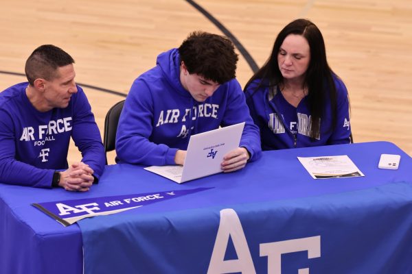 Signing his letter, senior Connor Sams commits himself to the Air Force Academy to play football. 