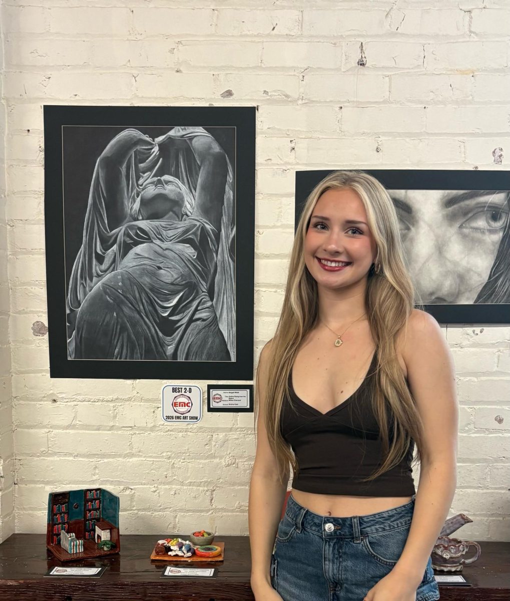 Junior Abigail Whitt stands with her Best of 2-D charcoal drawing.