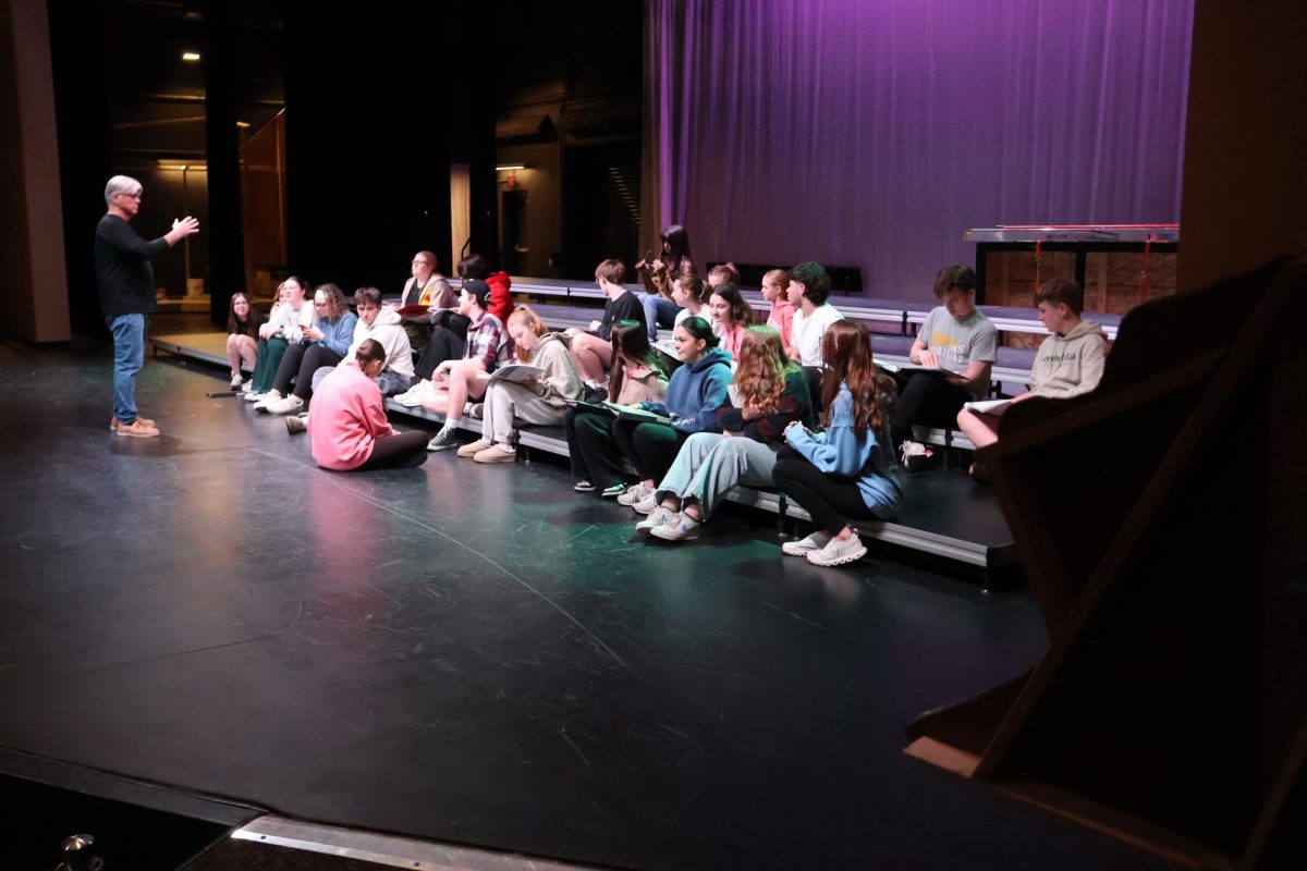Gesturing towards senior Eli Reinarz, who is saying one of his lines, musical director Pat Ribar leads the cast of "All Shook Up" through a sight read of the show on March 6. The first performance is on April 16 at 7 p.m.