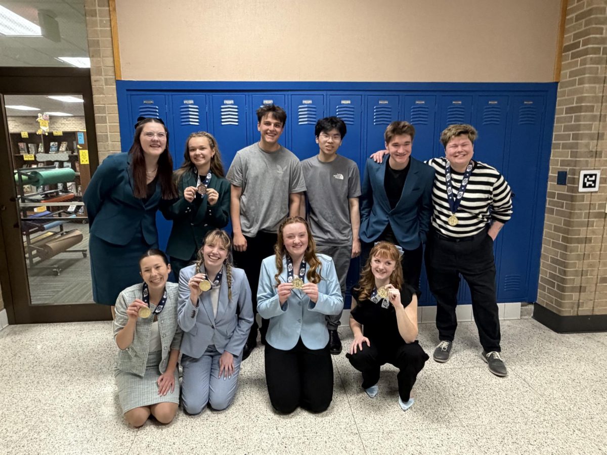 The State Speech qualifiers and head coach Grace Kimnach smile for a group photo after receiving their awards from the 2026 NSAA Class A State Speech Championships on Friday, March 27.