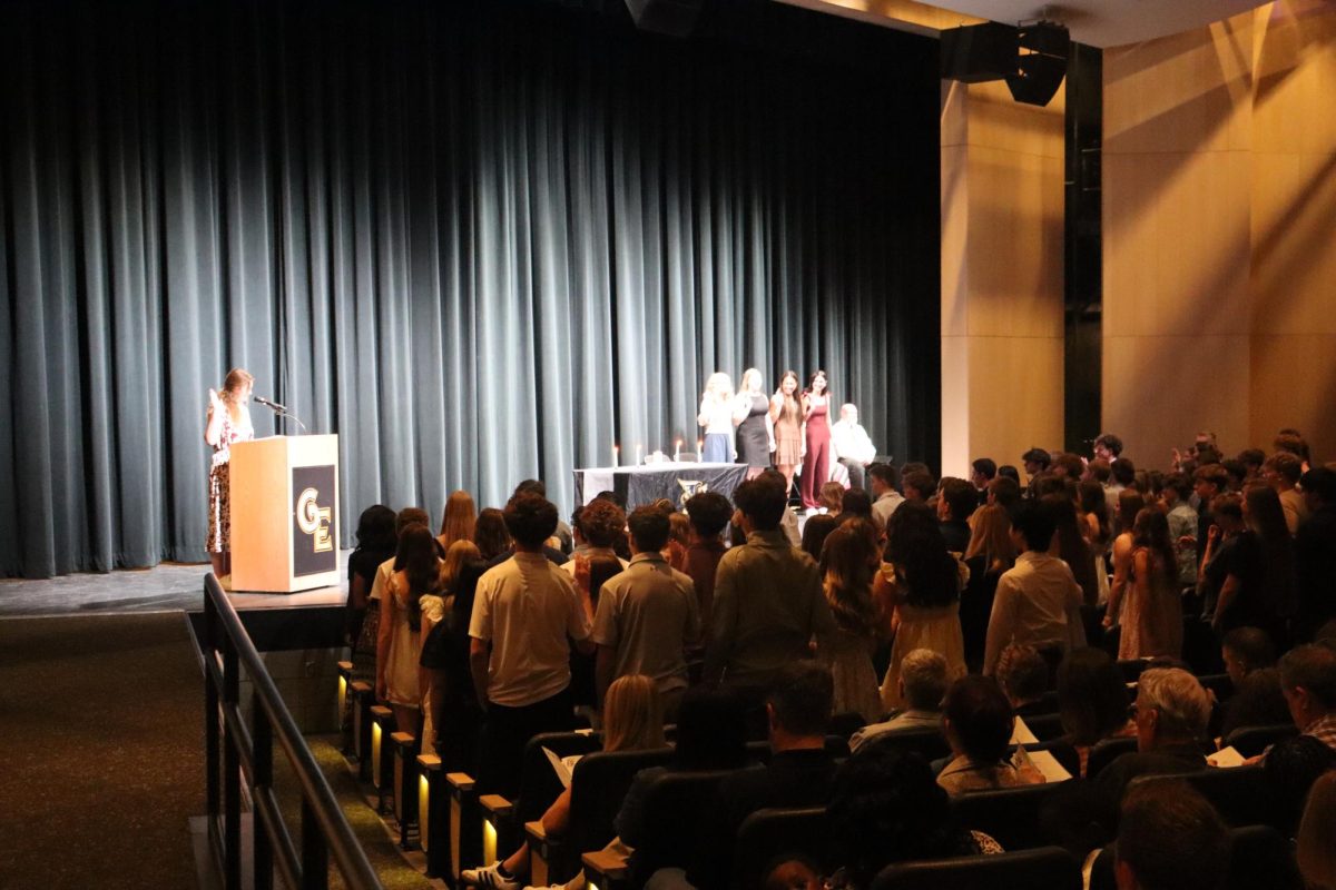During the NHS induction ceremony on March 29, the inductees raise their right hand and repeat the NHS pledge as NHS president, senior Madeline Petrick, recites it.