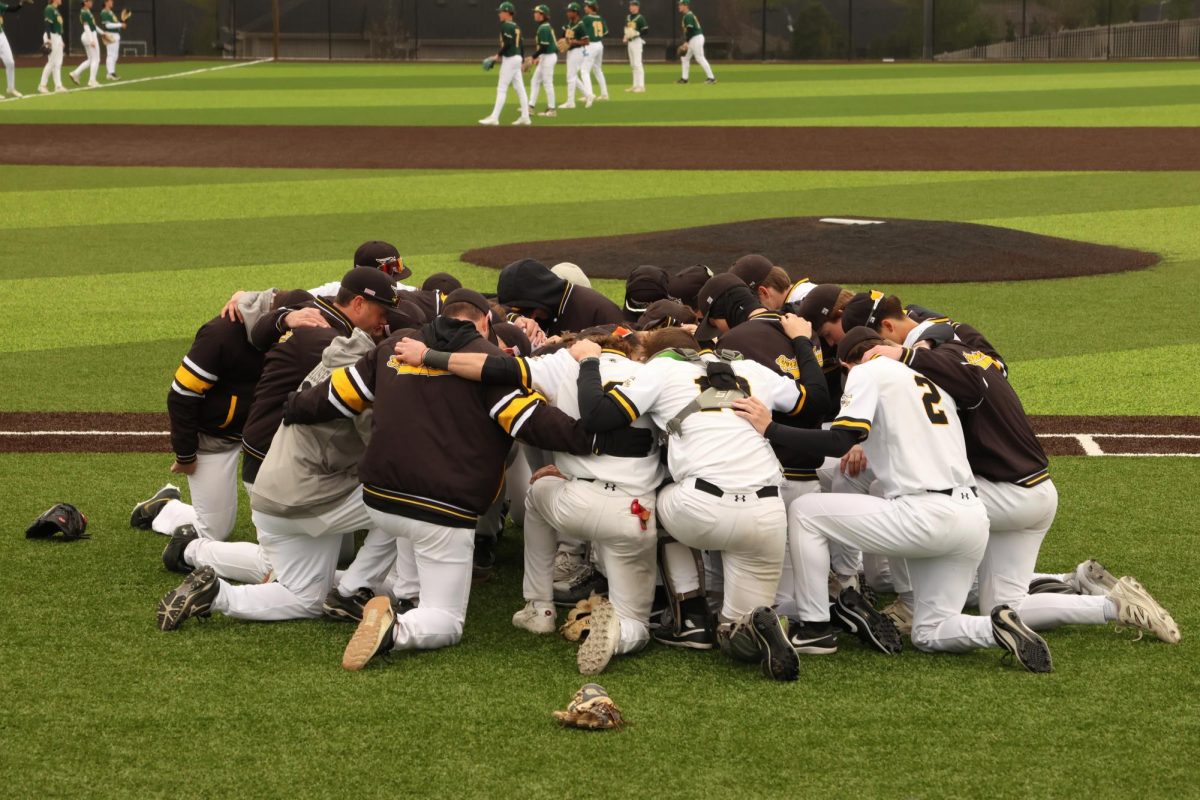 Before taking the field against the Gretna Dragons, the varsity Griffins kneel together as Coach Renshaw talks over them. The Griffins claimed the victory over the Dragons in a shutout style, 5-0, on April 27.
