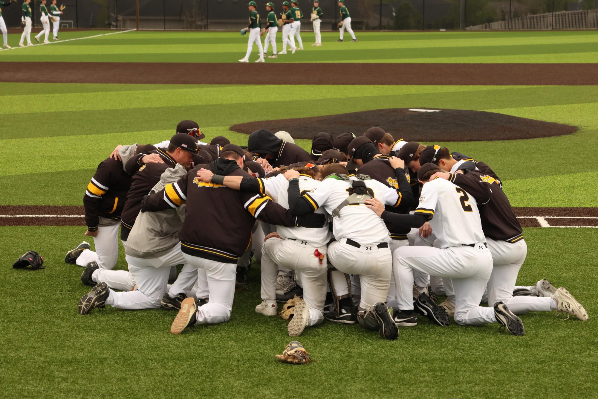 Before taking the field against the Gretna Dragons, the varsity Griffins kneel together as Coach Renshaw talks over them. The Griffins claimed the victory over the Dragons in a shutout style, 5-0, on April 27.