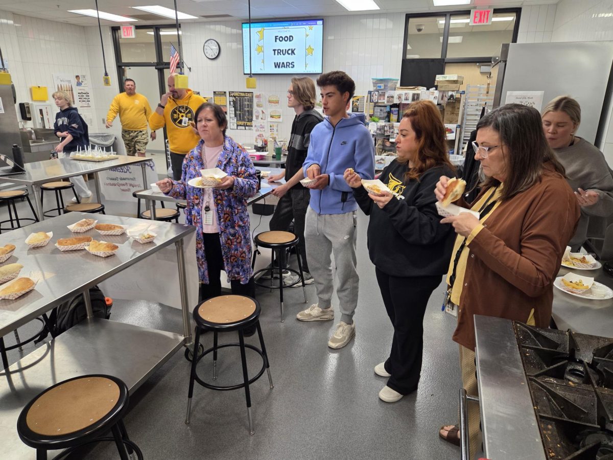 Secretary Jennifer Gydesen, junior Colton Kuhl, English teacher Chelsea Krebs and HAL teacher Dawn Nizzi enjoy the homemade Runzas they picked up from the food truck titled "Rabbi's Runzas" on May 6 in Room 337. 
