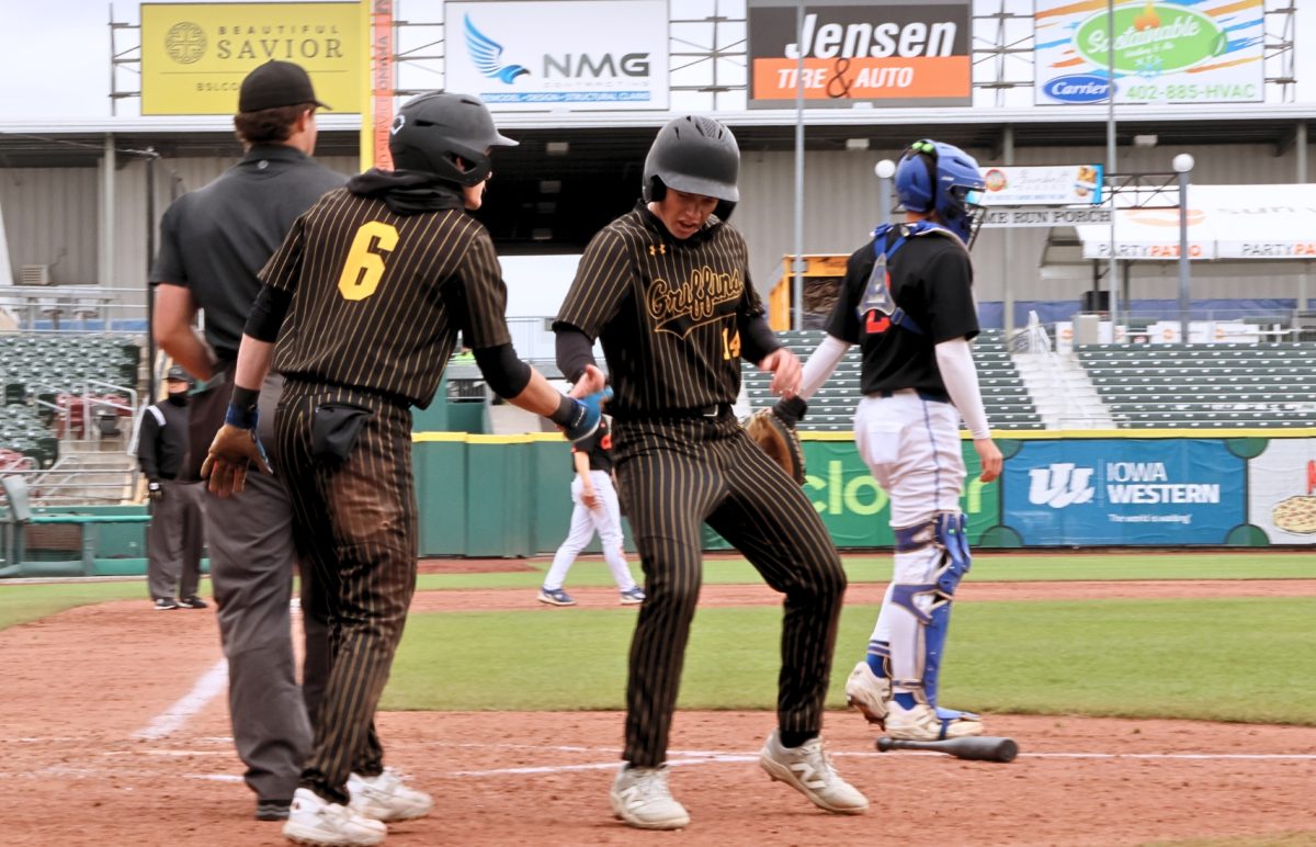 During the first inning of the May 21, NSAA Class B State Baseball playoff game against Gross Catholic, senior Jakub "Kuba" Brown low fives junior Mason Hayduk  after he crosses home plate. The Griffins ended the first inning with a 4-3 lead, but failed to score the remainder of the game, ultimately losing 12-4.