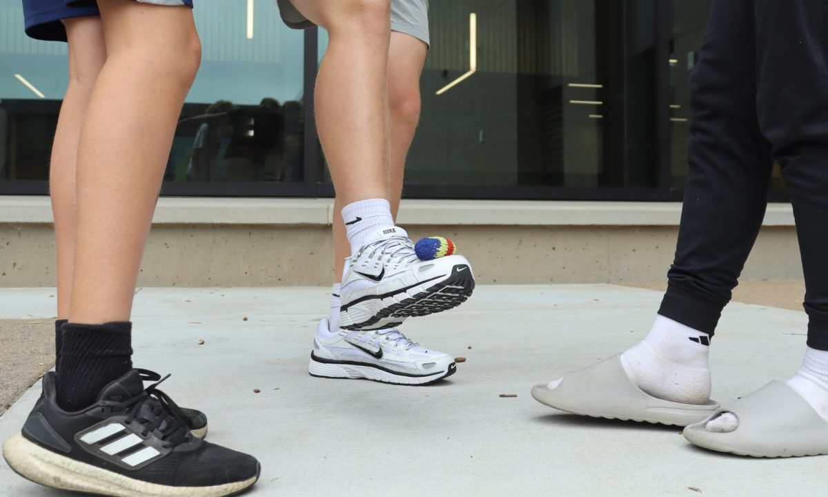 Playing hacky sack in the courtyard during free time, three friends try to get a rally going. The game has taken over the school, and students can be found playing in the courtyard and in the halls any chance they get.
